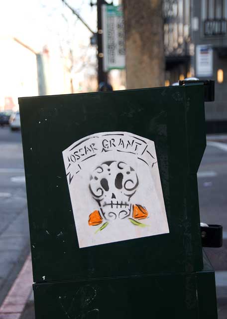 Graffiti affixed to a newsbox on Broadway in Oakland.