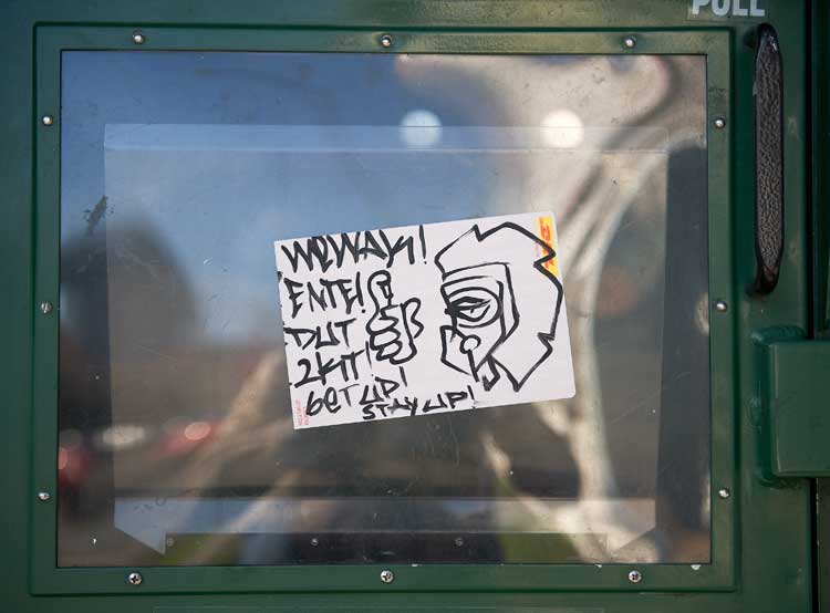 Graffiti on a sidewalk news box on Grand Avenue in Oakland.