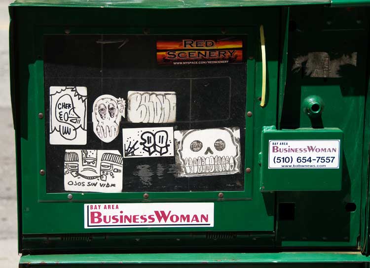 A sidewalk news box on Broadway in Oakland.