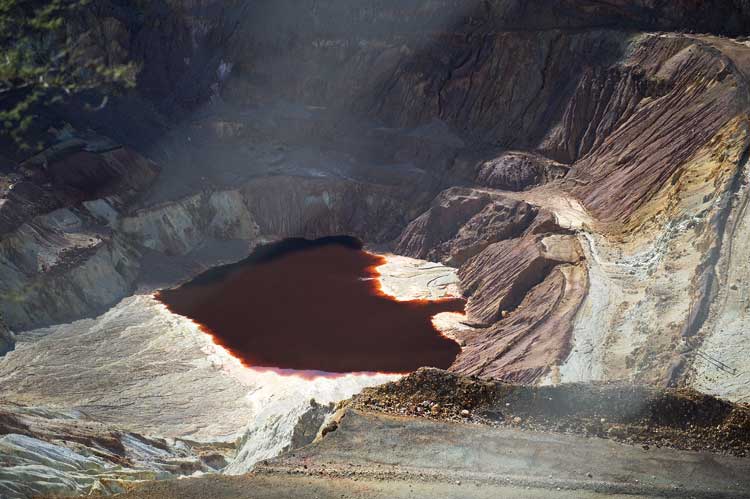 A copper colored pool at the bottom of the Bisbee open pit mine.
